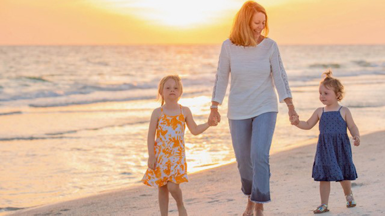 Tammy with her grandkids on the beach.