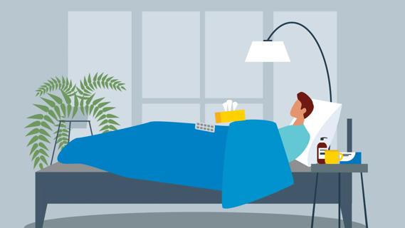 Person lying in bed sick, with assorted supplies around, like tissues, pills and hot beverage