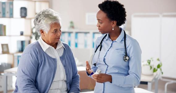 Healthcare provider holding asthma inhaler, talking with patient in medical office