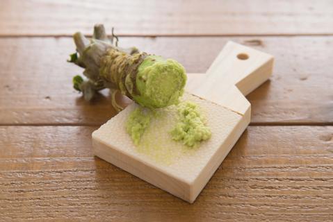 Wasabi root partially ground up on a mini cutting board